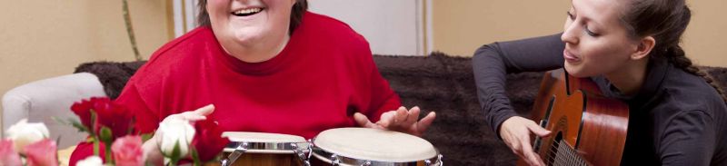 An adult with learning disabilities playing the drums